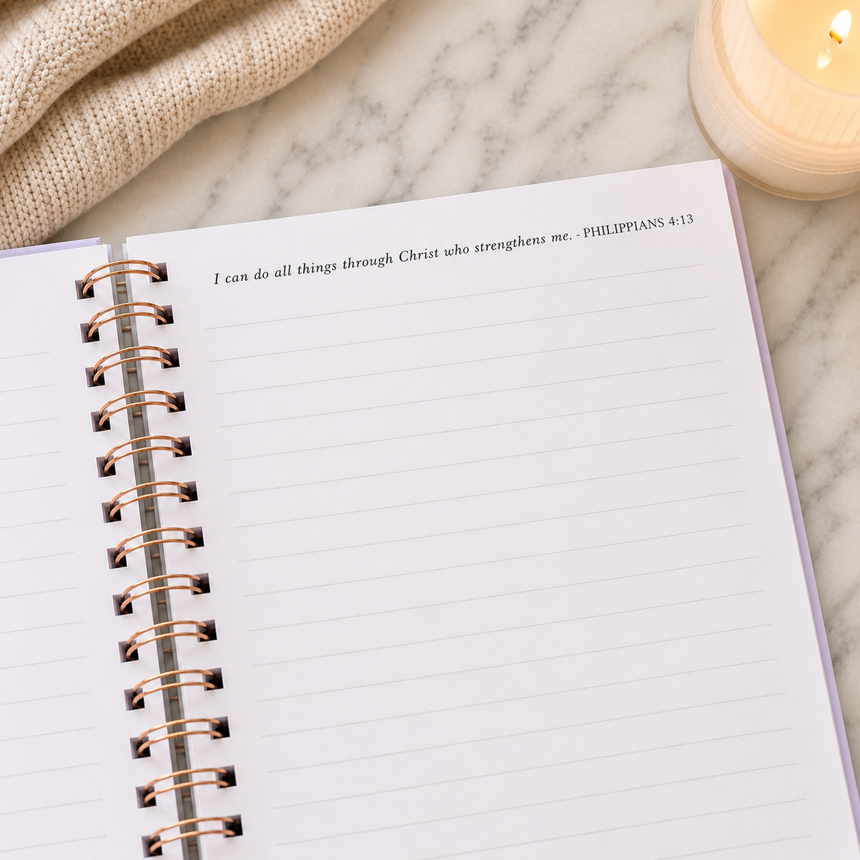 Open notebook with bible scripture on a marble surface with a candle