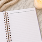 Open notebook with bible scripture on a marble surface with a candle